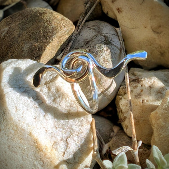 Bijou d'art bague Mélodie en argent poli, vue de près montrant la spirale et les courbes du motif musical.