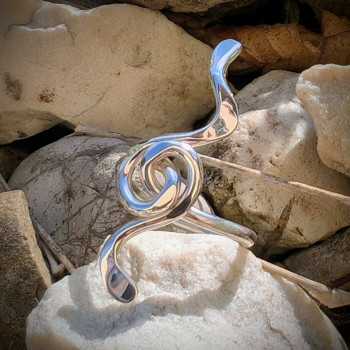 Gros plan extérieur sur la bague Mélodie en argent massif, motif serpentin ou clé de sol artistique pour femme.