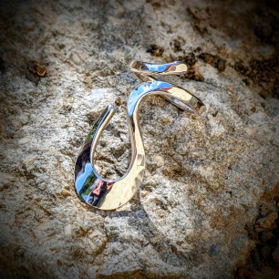 Gros plan Bague Volute Douce argent 925 fait main sur roche texturée.