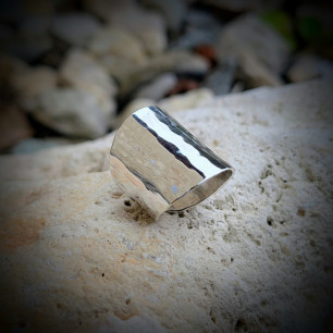 Bague manchette de style moderne, posée sur la roche pour un rendu naturel.